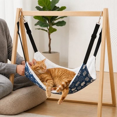 Hamac pour chat sur suspension en bois avec un chat roux dormant dedans