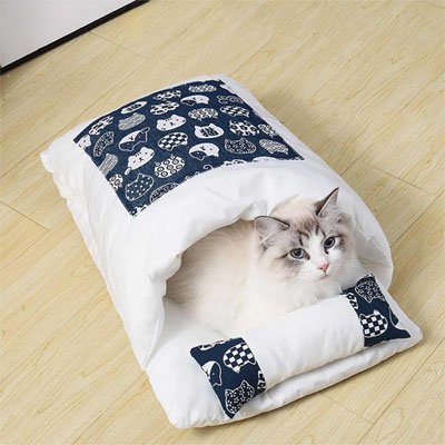 Lit chat en forme de vrai petit lit bleu et blanc avec chat dedans