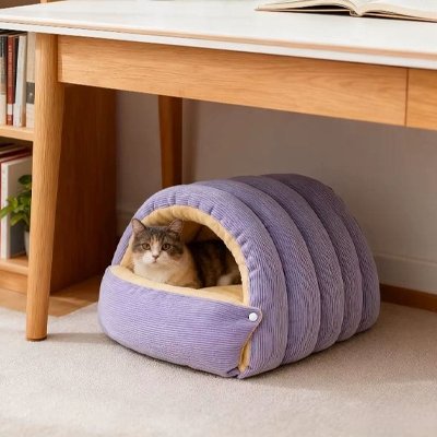 Lit pour Chat en forme de tunnel mauve installe sous un bureau avec un chat dedans 