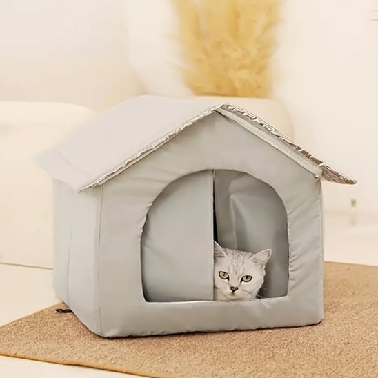 maison pour chat "extérieur" beige clair sur pieds avec un chat dedans