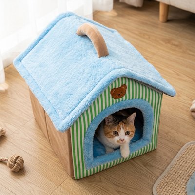 Maison pour les chats en forme de petite maison chat assit dedans