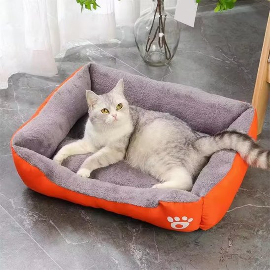 Panier a chat rectangulaire orange avec un chat dedans