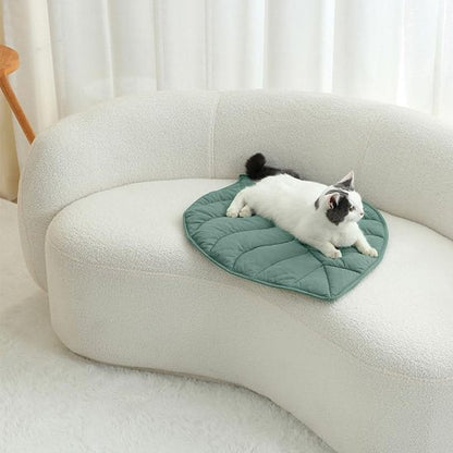 tapis chat forme de feuille verte avec un chat couche dessus